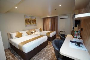 吉隆坡Dê MOCCIS Boutique Hotel的酒店客房配有两张床和一张书桌
