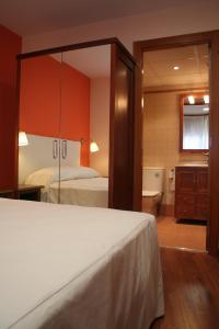 塔雷加Apartaments Tarrega Lagranja的一间卧室配有一张床,浴室设有浴缸