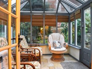 新米尔顿Smugglers Cottage的温室设有两张摇椅和窗户