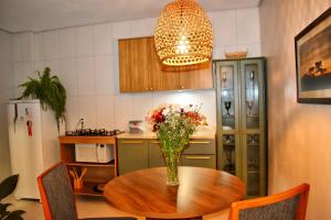 圣弗朗西斯科-迪保拉Apartamento da Júlio的厨房配有一张桌子,上面放着花瓶