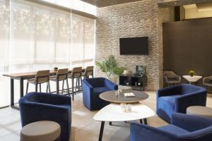 西棕榈滩Residence Inn by Marriott West Palm Beach Downtown的餐厅设有蓝色的桌椅和电视。