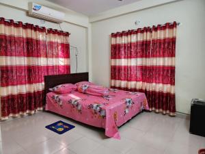 达卡Aaira guest house的一间卧室配有红色窗帘的粉红色床