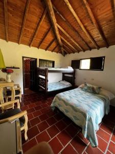 布卡拉曼加Finca Hacienda Casa Prada的一间带两张床的卧室,位于一个拥有木制天花板的房间