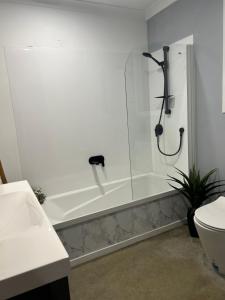 Parua BayJordan Place的白色的浴室设有浴缸和卫生间。