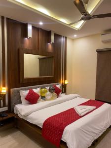 RūpnagarHotel Sukoon Bharatgarh的一间卧室配有一张带红色枕头的大床