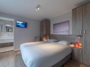 科莱恩斯普拉特Beautiful holiday home in Colijnsplaat with garden的一间带大床的卧室和一间浴室
