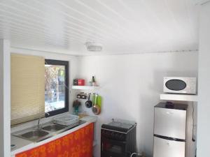 RotoavaKoriKori House Fakarava的一间带水槽和冰箱的小厨房
