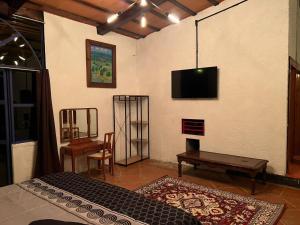迪坡斯特兰Los Cruxes的一间设有床铺和墙上电视的房间