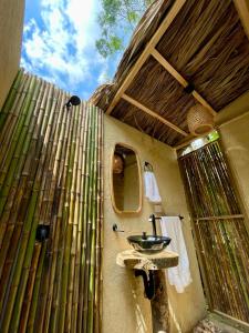 卡利ALMAH GLAMPING的一间带水槽和竹墙的浴室