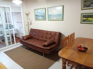 卡耐特蒂贝兰格V&M Canet的客厅配有棕色皮沙发和桌子