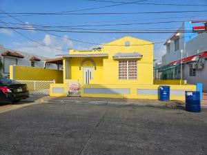 阿雷西博Beach Getaway with Cozy 2 Bedrooms near the Ocean, Arecibo的街道边的黄色房子