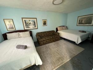 阿雷西博Beach Getaway with Cozy 2 Bedrooms near the Ocean, Arecibo的一间带两张床和一张沙发的客厅