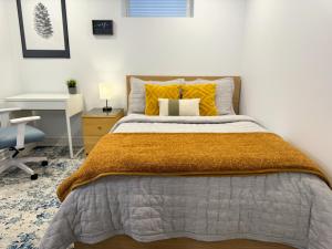 惠特比Whitby Private Rooms的一间卧室配有一张带黄色枕头的床和一张书桌