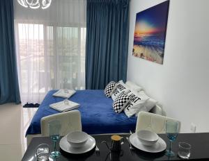 迪拜Great view, Dubai SportCity, parking included, nice Apartments的一间卧室配有蓝色的床和桌椅