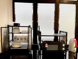 瓜拉丁加奴The Urban Lodge 1的厨房设有2扇窗户和1个带餐具的架子。