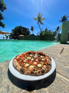迪克韦勒Casa Smeralda的坐在水边盘子上的比萨饼