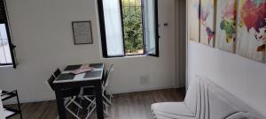 塞斯托卡伦德Lago Maggiore Lake Me Home apartment的客房设有书桌、椅子和窗户。