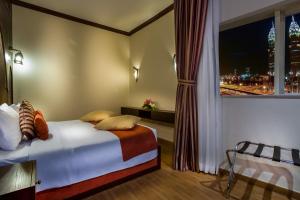 迪拜第一中央套房公寓式酒店的一间卧室设有一张床和一个美景窗户。