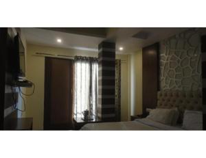 穆索里Hotel Valley View, Mussoorie的一间卧室设有一张床和一个窗口
