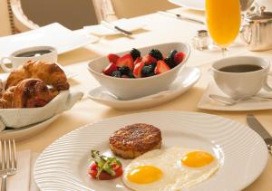 拉合尔Hotel Day In Emporium的一张桌子,上面放着一盘早餐食品和一碗水果