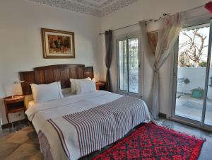 拉马萨达尔苏阿德旅馆的一间卧室配有一张红色地毯的大床