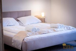 大特尔诺沃Hotel Kiev的一张带白色床单和毛巾的床