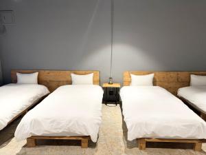 高松Hotel art rock的配有白色床单的客房内的三张床