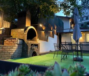 普雷代亚尔Pension Casa del Sol Predeal的庭院设有石炉和桌椅。