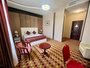 埃里温亚美尼亚皇宫酒店的酒店客房,配有床、桌子和椅子