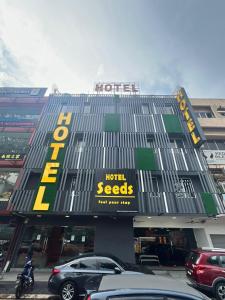 吉隆坡Seeds Hotel Cheras Maluri的门前有车辆停放的酒店