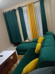 EmbuEmbu Paradise 1 bedroom AirBNB的客厅配有带黄色枕头的绿色沙发