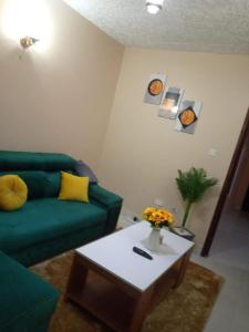 EmbuEmbu Paradise 1 bedroom AirBNB的客厅配有绿色沙发和茶几
