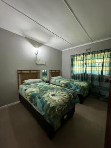 爱德华港Apt 66 Eden Wilds Umtamvuna Getaway的一间卧室设有两张床和两个窗户。