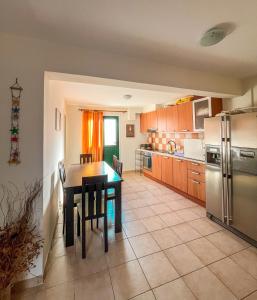 梅加尼西岛Mistral Houses的厨房配有桌子和不锈钢冰箱。