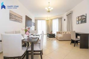 迪拜Luxurious 2BR Apartment near Palm Jumeirah的用餐室以及带桌椅的起居室。