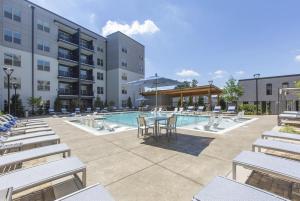 亚特兰大Luxury 2br Apartment (Buckhead)的酒店庭院设有桌椅和游泳池。