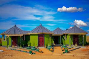 安博塞利Amanya 3-Bedroom Hut Amboseli的一排带黑色屋顶的绿色房屋