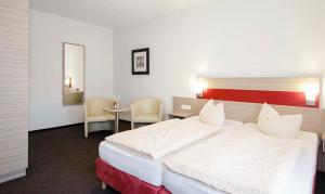 库克斯港Hotel Gasthof Zur Post的卧室配有一张白色的大床和一张桌子