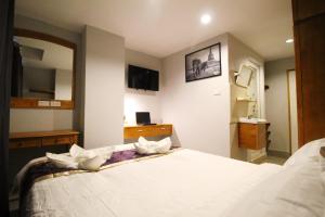 曼谷L Hotel的卧室配有一张带镜子的白色大床