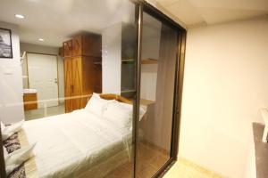 曼谷L Hotel的卧室配有白色的床和玻璃墙