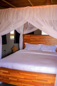 安博塞利Amanya 3-Bedroom Hut Amboseli的一间卧室配有一张带天蓬的大床