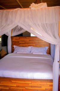 安博塞利Amanya 3-Bedroom Hut Amboseli的一间卧室配有一张带天蓬的白色床