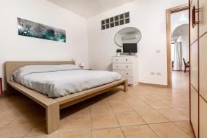 圣特雷莎加卢拉Fronte Mare Capo Testa的卧室配有1张床,铺有瓷砖地板。