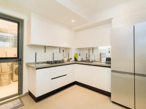 胡鲁马累Aira Residence - 2nd Floor 1007的白色的厨房配有白色橱柜和窗户