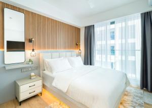 胡鲁马累Aira Residence - 2nd Floor 1007的卧室设有白色的床和大窗户