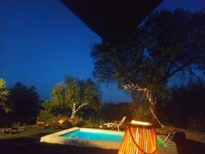 耶斯特Casa Rural Puente de la Vicaria by Jaxun的夜间在院子里的游泳池