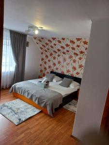 米奥修德萨斯VILA SIMONA的一间卧室配有一张带花卉墙壁的床