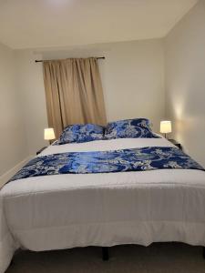 埃德蒙顿Furnished Room-5 Close to U of A in Edmonton - with Shared Spaces的一间卧室配有一张带蓝白色床单的大床