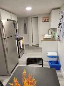 埃德蒙顿Furnished Room-5 Close to U of A in Edmonton - with Shared Spaces的带冰箱和桌子的厨房