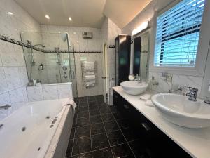 汉默温泉Fontainebleau Luxury B&B的浴室配有2个盥洗盆、浴缸和淋浴。